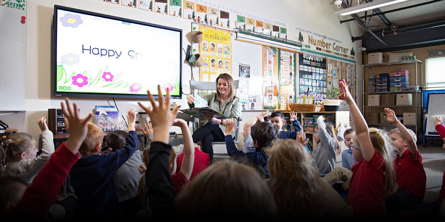 Classroom with children raising their hands