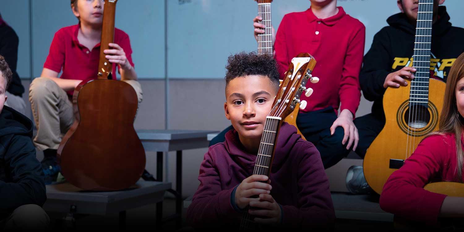 Students in the classroom with guitars.