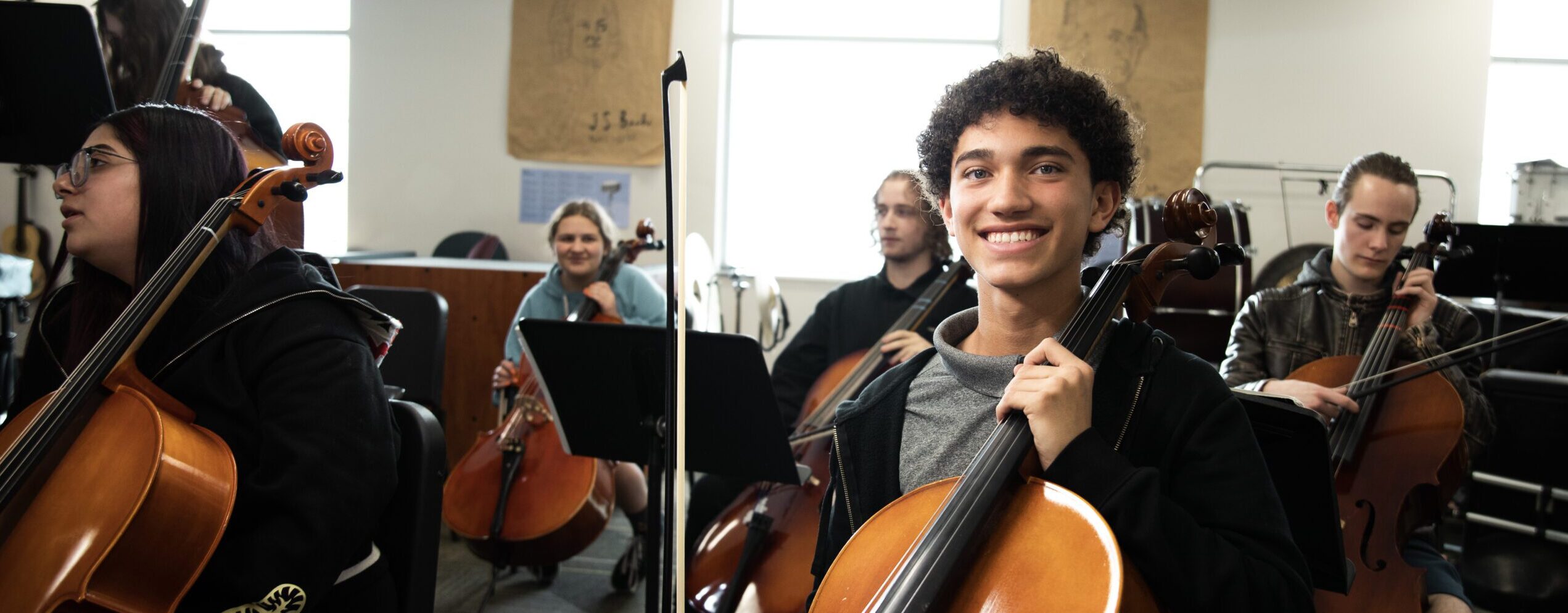 Student smiling holding an instrument